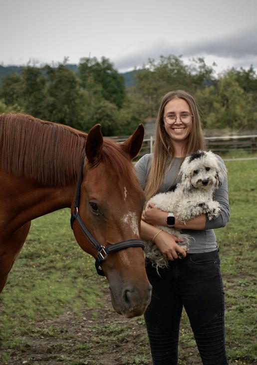 Foto von Sofie Strohhäusl, mit Pferd Farbe Fuchs und Pudel auf dem Arm, schwarz-weiß